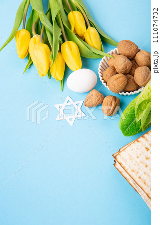 Passover Greeting Card with Matzah, Waluts and Yellow Tulip Flowers on Blue Background. 111074732