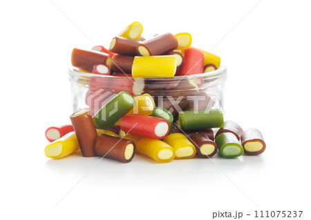 Sweet colorful chewy candy sticks in jar isolated on white background. 111075237
