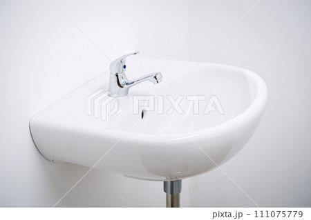 A white sink in a public toilet, a clean sink on a white background A white sink in a public toilet, a clean sink on a white background 111075779