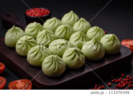 Raw khinkali or green dumplings with salt, spices and herbs Raw khinkali or green dumplings with salt, spices and herbs 111076396