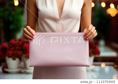 Pink clutch, women's bag in the hands of a woman 111076909