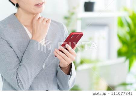 スマートフォンを使うビジネスウーマンの口元 スマートフォンを使うビジネスウーマンの口元 111077843