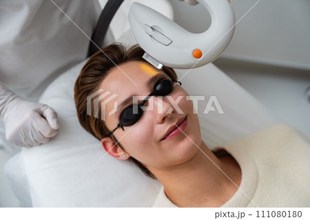 Phototherapy, photorejuvenation, IPL in a beauty salon. Care for a woman's face. 111080180