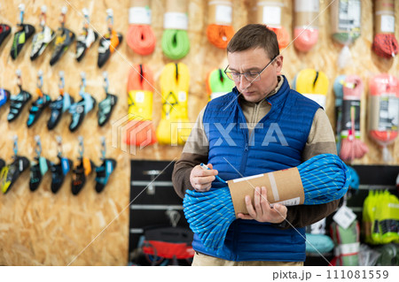 Man view rope cable for climbing and evaluate its thickness 111081559