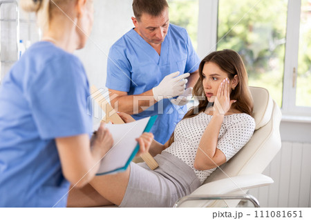 Male plastic surgeon consulting woman before facial contouring Male plastic surgeon consulting woman before facial contouring 111081651