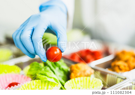弁当を作る食品工場の女性 顔無し 弁当を作る食品工場の女性 顔無し 111082304