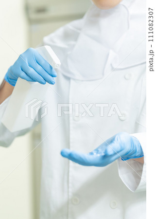 除菌スプレーを使う食品管理者　顔無し 111082307