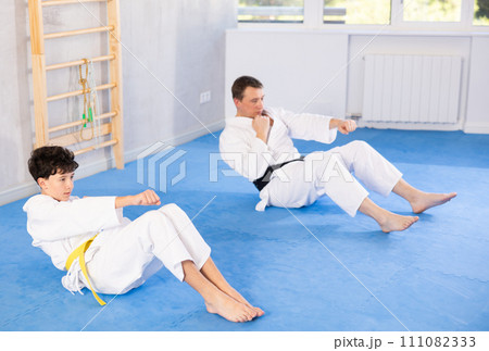 Man and boy teenager doing abdominal exercises 111082333