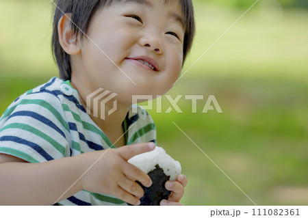 公園でおにぎりを食べる男の子 公園でおにぎりを食べる男の子 111082361