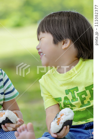 公園でおにぎりを食べる男の子たち 公園でおにぎりを食べる男の子たち 111082377