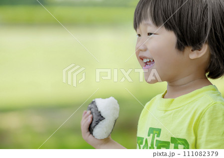 公園でおにぎりを食べる男の子 公園でおにぎりを食べる男の子 111082379