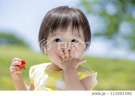 公園でミニトマトを持つ女の子 111082390