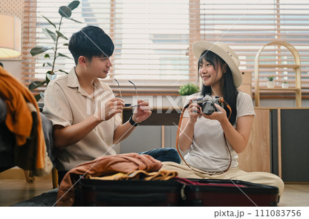 Lovely young couple preparing clothes, getting ready for honeymoon holiday trip Lovely young couple preparing clothes, getting ready for honeymoon holiday trip 111083756