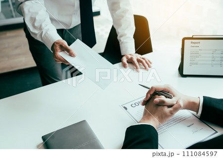 Male employee handed out a resignation envelope to the manager. 111084597