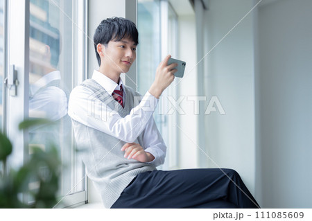 学生 スマホを見ている男子学生 学生 スマホを見ている男子学生 111085609