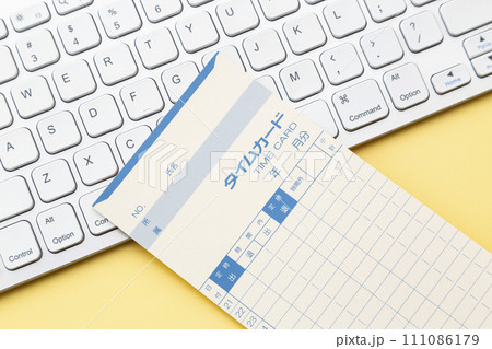 黄色背景にキーボードとタイムカード 黄色背景にキーボードとタイムカード 111086179