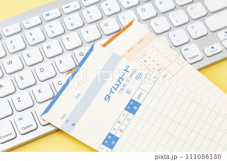 黄色背景にキーボードとタイムカード 黄色背景にキーボードとタイムカード 111086180