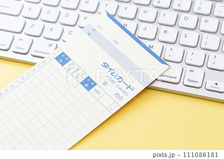 黄色背景にキーボードとタイムカード 黄色背景にキーボードとタイムカード 111086181