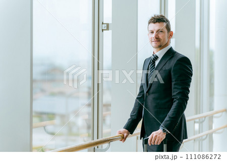 駅・ターミナルで待ち合わせをする外国人ビジネスマン（白人男性・グローバル・外資系） 111086272