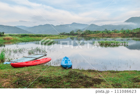 Landscape boat on the lake reflects a blue sky. The cloudy sky is reflected in the mirror like smooth lake surface. Landscape boat on the lake reflects a blue sky. The cloudy sky is reflected in the mirror like smooth lake surface. 111086623