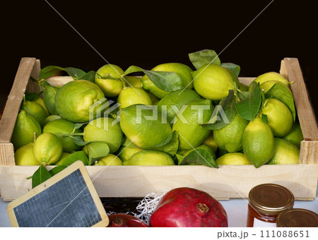 Local market. Boxes of lemons. Fresh fruit with leaves in boxes at the open air local food market. Wholesale depot of exotic fruits. Local produce at the farmers market. 111088651