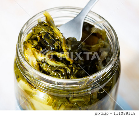 Pickled chard on fork in glass jar 111089318