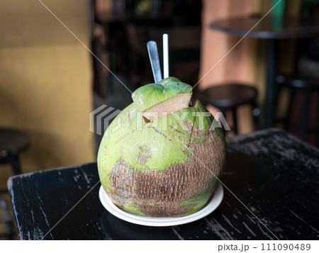 Coconut fruit water drink, on a table in a cafe. Coconut fruit water drink, on a table in a cafe. 111090489