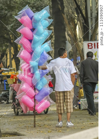Mexico City, Mexico. Jan 11, 2024. A vibrant cotton candy vendor on the street, casually tempting passersby with their sweet treats. 111090907