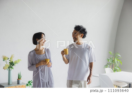 マグカップを持って話をするカップル 111093640