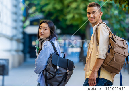 International students walking near the campus and smiling. 111093953