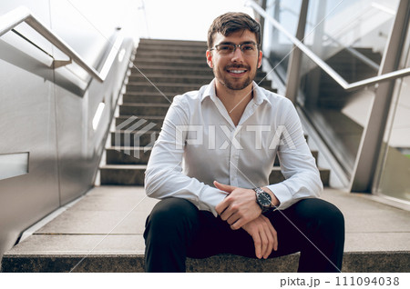 Contented young man looking confident and smiling Contented young man looking confident and smiling 111094038