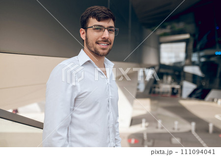Contented young man looking confident and smiling Contented young man looking confident and smiling 111094041