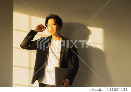 夕方の窓辺の男性 111094131