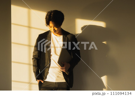 夕方の窓辺の男性 111094134