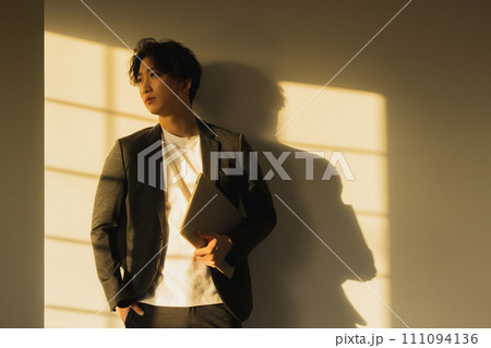 夕方の窓辺の男性 111094136