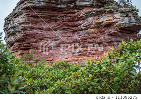 Majestic Red Sandstone Cliff Surrounded by Lush Greenery 111096275