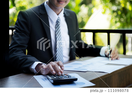 Businessmen bookkeeper hand holding pen and use calculator, laptop analysis the graph for Setting challenging business goals and ready to achieve target at home office Businessmen bookkeeper hand holding pen and use calculator, laptop analysis the graph for Setting challenging business goals and ready to achieve target at home office 111098078