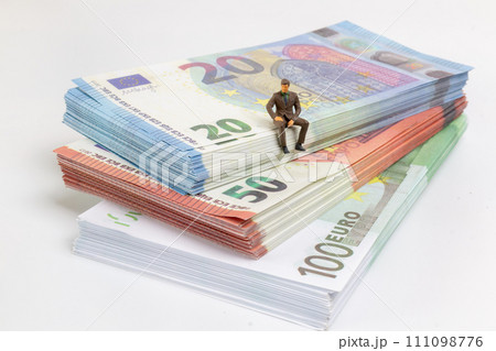 Miniature businessman navigates the financial landscape, surrounded by Euro banknotes, Miniature businessman navigates the financial landscape, surrounded by Euro banknotes, 111098776