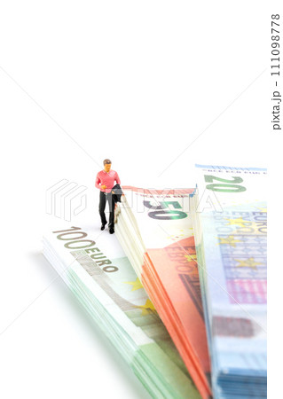 Miniature businessman navigates the financial landscape, surrounded by Euro banknotes, Miniature businessman navigates the financial landscape, surrounded by Euro banknotes, 111098778