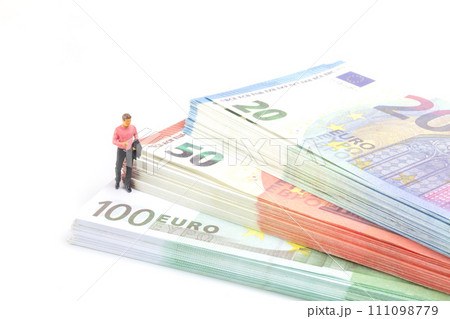 Miniature businessman navigates the financial landscape, surrounded by Euro banknotes, 111098779