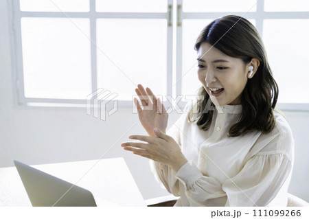リビングでオンライン会議をする若い女性 111099266