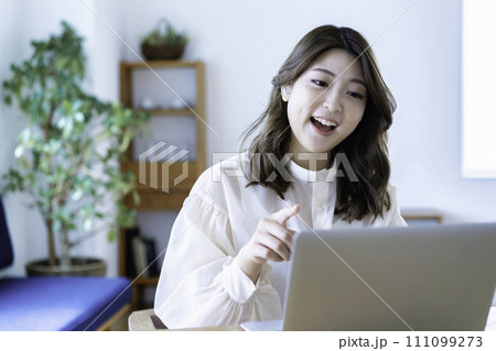 リビングでオンライン会議をする若い女性 111099273