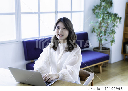 リビングでオンライン会議をする若い女性 111099924