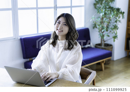 リビングでオンライン会議をする若い女性 111099925