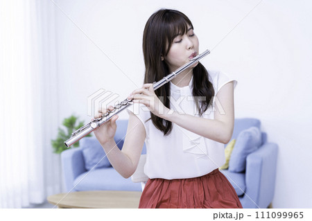 リビングでフルートを吹く女性 111099965