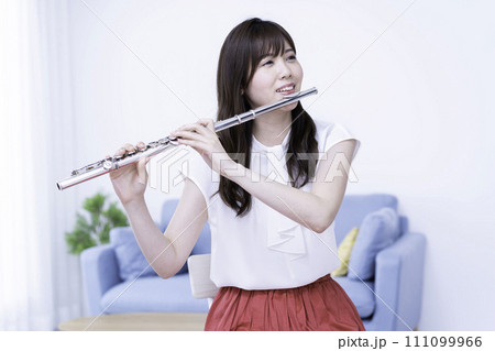 リビングでフルートを吹く女性 リビングでフルートを吹く女性 111099966
