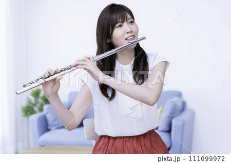 リビングでフルートを吹く女性 111099972
