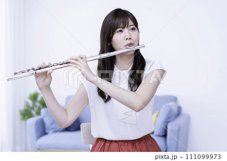 リビングでフルートを吹く女性 リビングでフルートを吹く女性 111099973