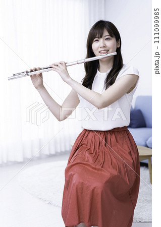 リビングでフルートを吹く女性 111099985