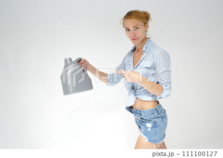 Woman holding canister of motor oil on light background Woman holding canister of motor oil on light background 111100127
